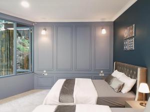 ein Schlafzimmer mit einem Bett und einem großen Fenster in der Unterkunft Villa Airis By The Villas 100 in Puncak