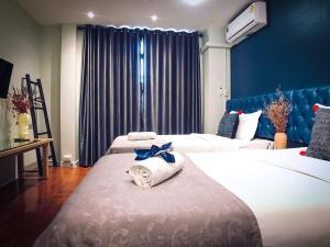 ein Hotelzimmer mit 2 Betten und Handtüchern darauf in der Unterkunft Sabaiday Guesthouse Nimman in Chiang Mai