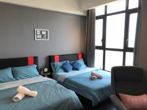 a bedroom with two beds and a chair and a window at 28 Boulevard Studio Suite Resort Facilities 3-6KM to Velocity MyTown KLCC in Kuala Lumpur