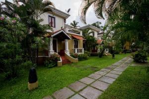 una casa con un patio verde con un camino en Villa 15 White Square Nirvana, Guirim, Parra, en Parra