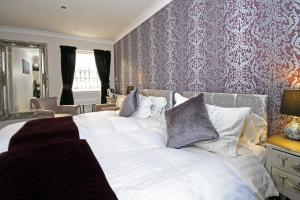 
a bed with a white comforter and pillows at The Horseshoe Inn in Eddleston
