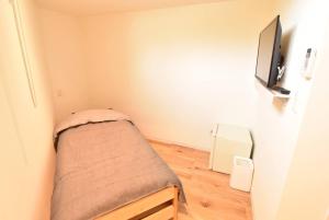 Habitación pequeña con cama pequeña y TV. en Enzo Due, en Tamano