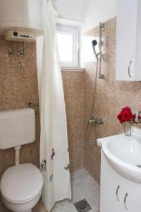 y baño con aseo, lavabo y ducha. en Apartment Gitara en Dubrovnik