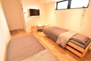 a bedroom with two beds and a flat screen tv at Enzo Due in Tamano