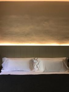 a bed with white sheets and pillows on top of it at Hostal Sa Rascassa in Begur