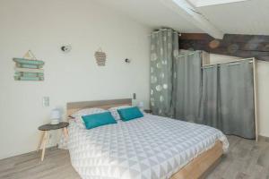 1 dormitorio con 1 cama grande con almohadas azules en Gare-capitole, en Narbona