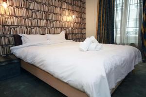 a bedroom with a large white bed with two towels at Cozy Apartment close to Cornavin Train Station and lake in Geneva