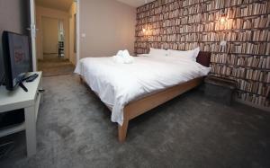 a bedroom with a large bed with a wall of books at Cozy Apartment close to Cornavin Train Station and lake in Geneva