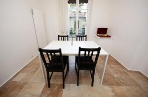 a dining room with a white table and chairs at Cozy Apartment close to Cornavin Train Station and lake in Geneva