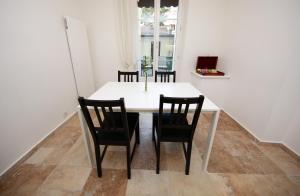 una sala da pranzo con tavolo e sedie bianchi di Cozy Apartment close to Cornavin Train Station and lake a Ginevra