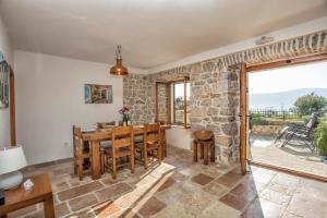 ein Esszimmer mit einer Steinmauer sowie einem Tisch und Stühlen in der Unterkunft Villa Ruza, Donja Lastva in Tivat