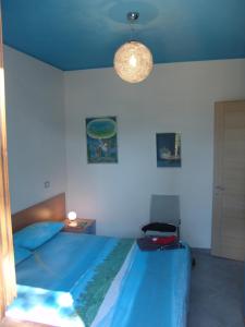 une chambre avec un lit avec une couverture bleue dans l'établissement Blue apartment, à Marina di Castagneto Carducci