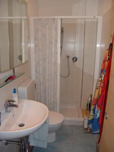 une salle de bain avec un lavabo, une douche et des toilettes dans l'établissement Blue apartment, à Marina di Castagneto Carducci 23 autres photos