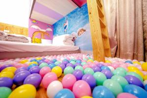 une pile de ballons dans une chambre avec un lit dans l'établissement Treasure House, à Luodong