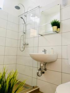 a white bathroom with a sink and a mirror at L&R Apartment in Győr