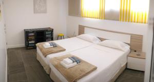 1 dormitorio con 1 cama blanca grande y 2 toallas en Villa Royale Trespalomas, en Maspalomas