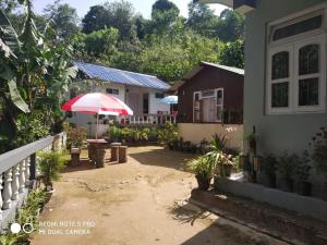 a patio with a red umbrella and a house at Mingma Homestay in Takdāh