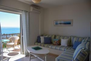 a living room with a couch and a view of the ocean at Thyme Glyfada Beach in Glyfada