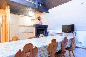 a kitchen with a table with chairs and a fireplace at Appartamento MARMOLADA - CANAZEI in Canazei