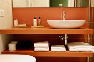 a bathroom with a sink and towels on a shelf at Al Ponticello in Comacchio