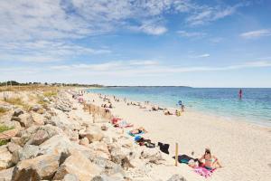 um grupo de pessoas sentadas numa praia em Ti Kabanouz em Arzon