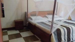 a bedroom with a bed with a mosquito net at Rainbow Motel Sembabule in Sembabule
