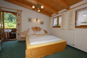 1 dormitorio con 1 cama en una habitación con ventana en Haus Tasser, en Mayrhofen