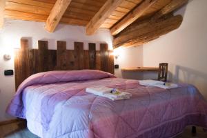 um quarto com uma cama grande e uma cabeceira em madeira em B&B Lo VAN - Camere al Verde Villaggio di Rumiod em Saint-Pierre