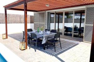 a dining table and chairs on a patio at Villa d’Aina * Propiedad privada con piscina in Cala en Bosc