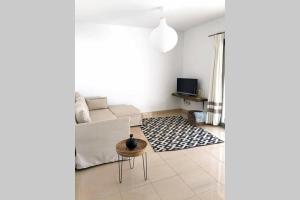 un soggiorno bianco con divano e tavolo di Villa d’Aina * Propiedad privada con piscina a Cala'n Bosch