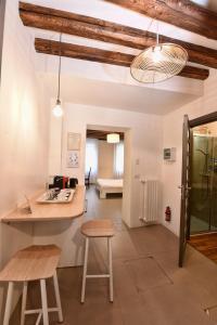eine Küche und ein Wohnzimmer mit einer Theke und Stühlen in der Unterkunft Sottopiano - comfort in the center in Venedig