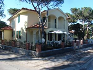 une maison blanche avec un parasol dans une rue dans l'établissement Blue apartment, à Marina di Castagneto Carducci