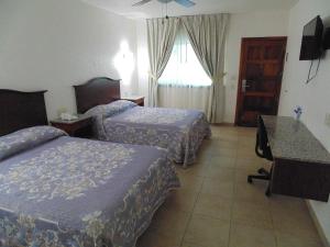 Postel nebo postele na pokoji v ubytování Hotel Hacienda