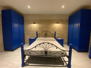 ein blaues Schlafzimmer mit einem Bett mit blauen Schränken in der Unterkunft Cosy private townhouse in heart of Senglea in Senglea