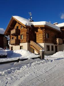 een gebouw met sneeuw op de grond ervoor bij Chalet Shany in Livigno