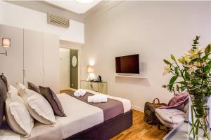 a hotel room with a bed and a tv at Orange Suites in Rome