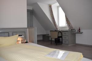 a bedroom with a bed and a desk and a window at Avenue Hotel in Nuremberg