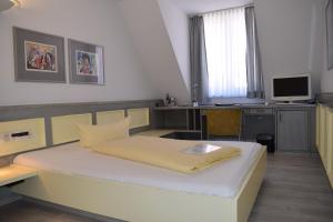 Schlafzimmer mit einem Bett und einem Schreibtisch mit einem Computer in der Unterkunft Avenue Hotel in Nürnberg