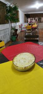 una pizza sentada en una mesa sobre una alfombra colorida en Sos Hostel en Camaçari