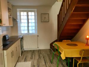 une cuisine avec une table jaune et un escalier dans l'établissement Gite Vénérand, à Acquigny