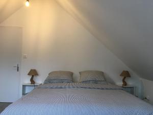 - une chambre avec un lit et 2 lampes sur 2 tables dans l'établissement Gite Vénérand, à Acquigny