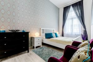 - une chambre avec un lit, une commode et une fenêtre dans l'établissement Luxury Paulay street Apartment, à Budapest
