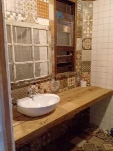 a bathroom with a white sink and a window at Tainha da Praia Aparthotel in Bombinhas