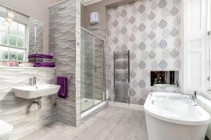 a bathroom with a tub, toilet and sink at Haymarket Apartments in Edinburgh