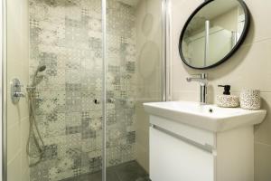 a bathroom with a shower and a sink and a mirror at King David 19 Apartment in Jerusalem
