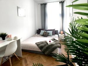1 dormitorio con cama, escritorio y planta en Apartament Peowiaków Queens en Lublin
