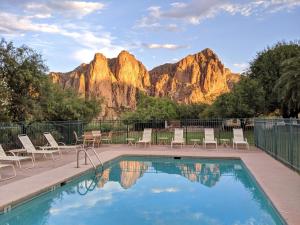 uma piscina com cadeiras e montanhas ao fundo em Saguaro Lake Ranch em Fountain Hills