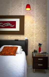 1 dormitorio con 1 cama y mesita de noche con sofá cama en Pioneiro Hotel, en Teixeira de Freitas