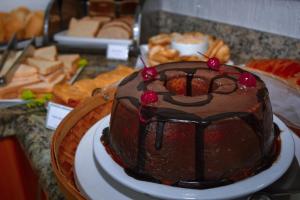 una tarta de chocolate con cerezas sobre una mesa en Pioneiro Hotel, en Teixeira de Freitas