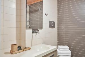 La salle de bains est pourvue d'un lavabo blanc et d'une douche. dans l'établissement Contemporary & Comfy Apt next to Acropolis Museum, à Athènes